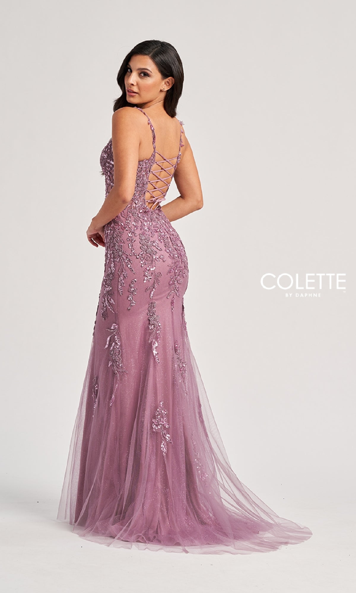 Model wearing the Colette CL8210 long prom dress, a fitted mauve mermaid gown with sequin embellishments and lace-up back, posing against a plain light background.